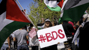 A woman yells while holding a sign &quot;#BDS,&rdquo; referring to &ldquo;Boycott, Divestment, Sanctions,&rdquo; in front of the Israeli Consulate in Los Angeles on May 14, 2018